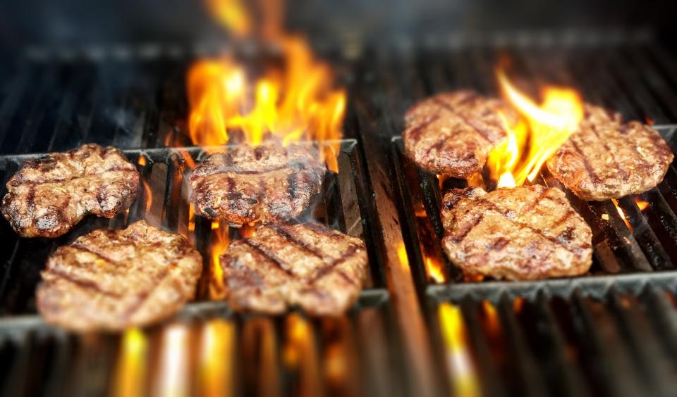 Steaks searing over an open flame grill