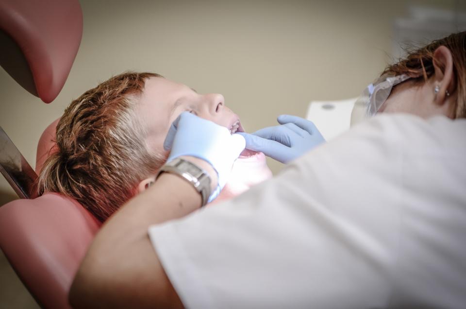 Dentist gently examining a young patient